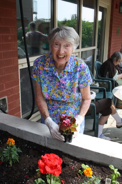 Senior female client planting flowers