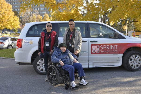 client in wheelchair and 2 staff in front of wheelchair accessible van