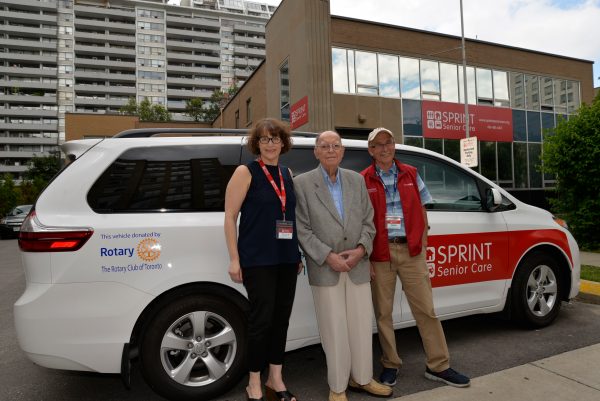 3 standing in front of Rotary Club Donated Van